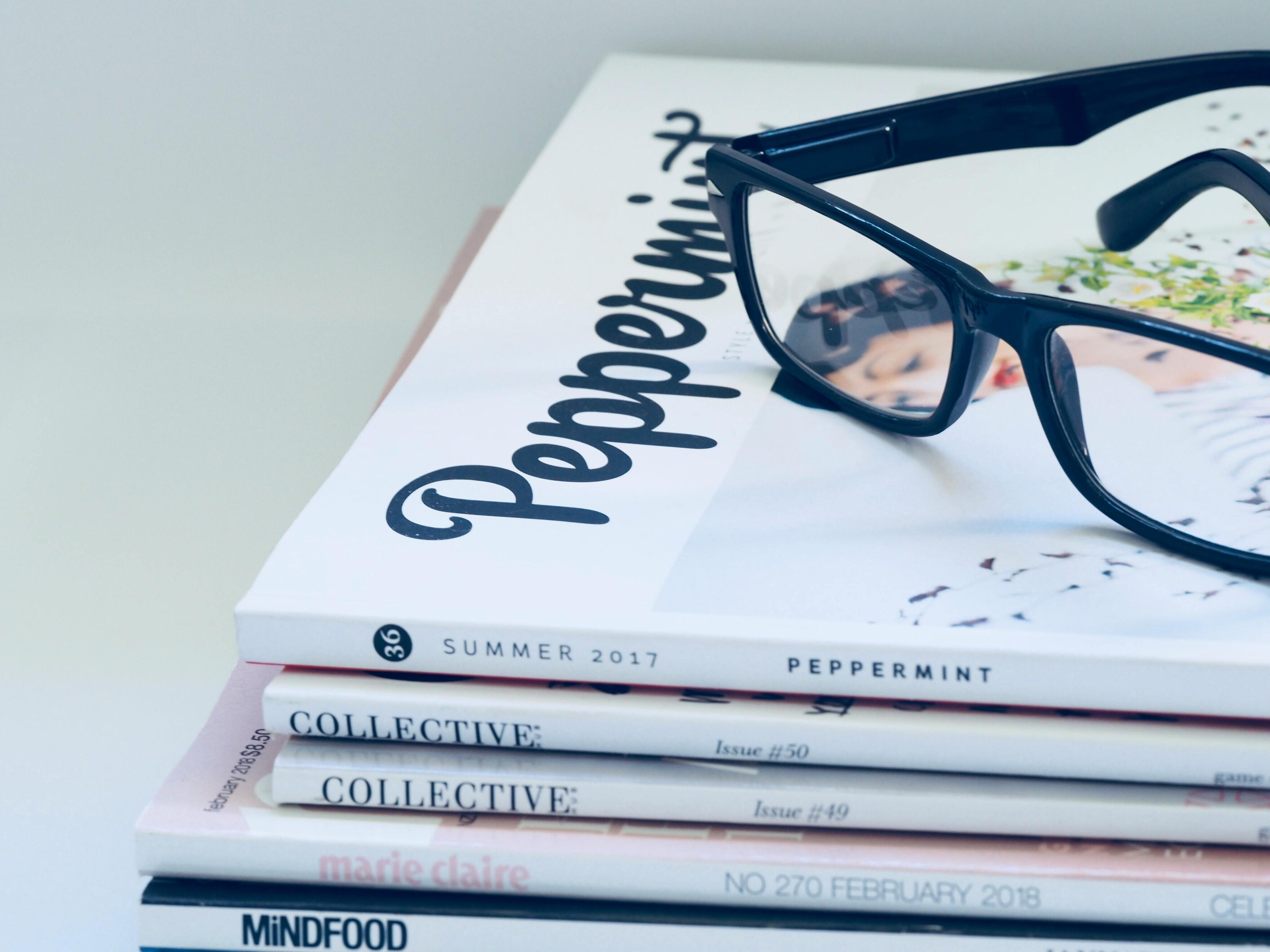 Glasses on a pile of magazines.